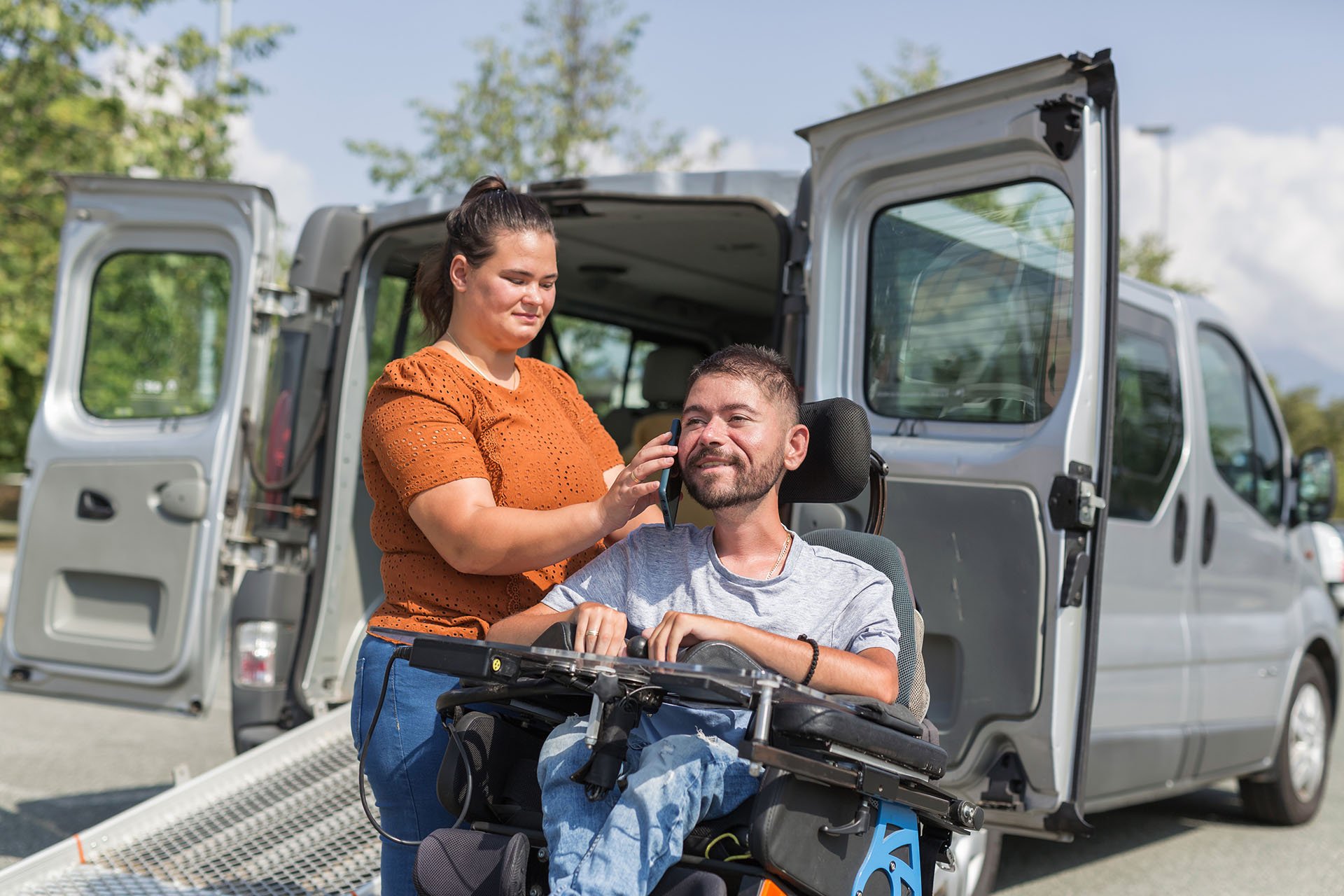 support worker and client with wheelchair outside of a van