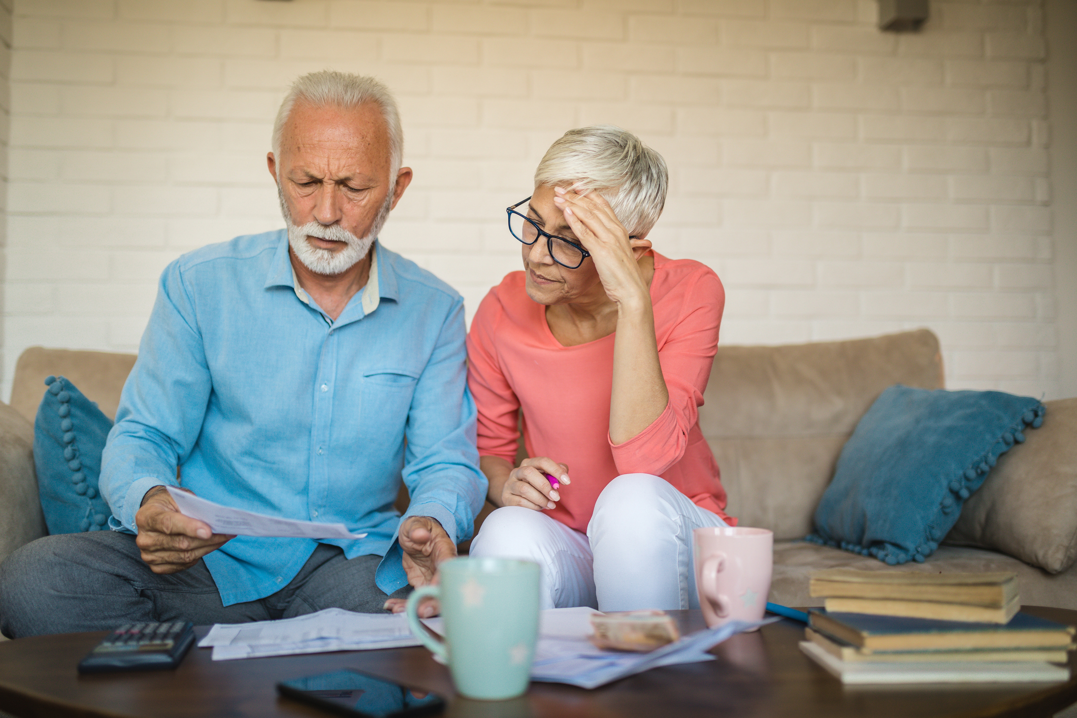 Older couple reviewing bills together and feeling stressed